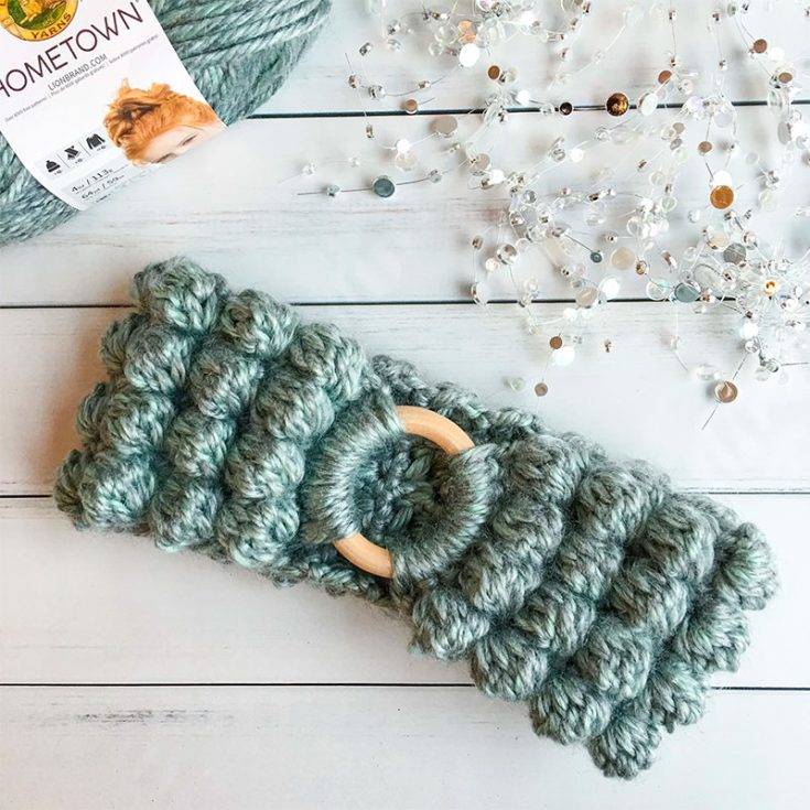 This cute ear warmer is made with super bulky yarn and the texture comes from using bobble stitches. It can also be hung around your neck as a cowl.