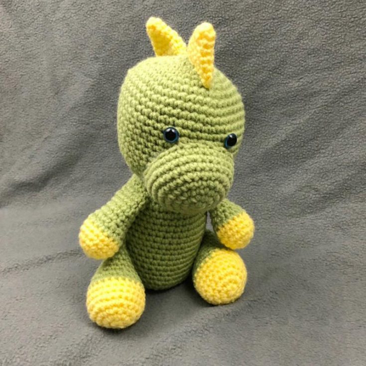 Worked in the round, this T-rex-like dino is the go-to for soft dinosaur plushies. Most of his parts are sewn onto his body, so some sewing skill is required, and he sits 9.5&rdquo; tall.