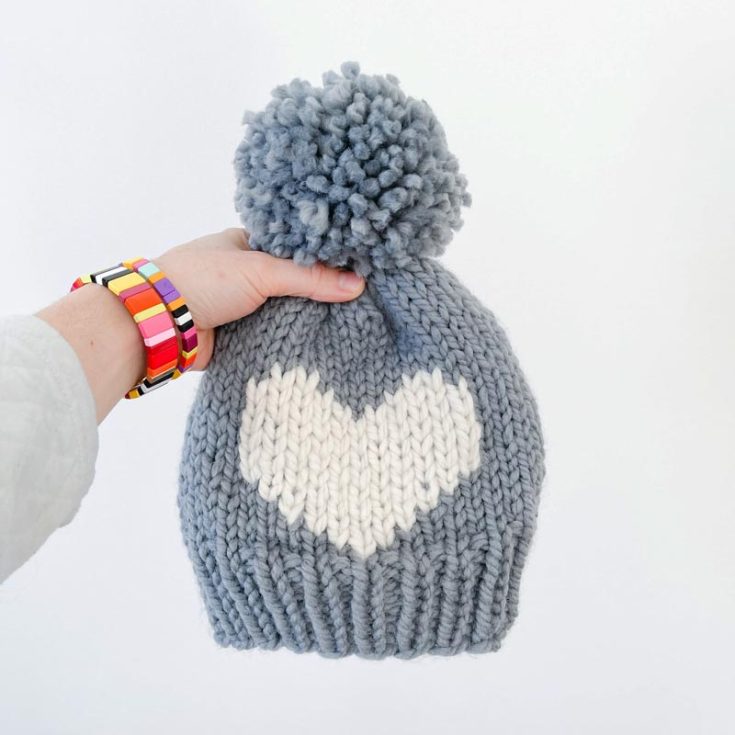 Check out this minimalistic winter beanie pattern with a sweetheart motif in the center! The best part of this pattern is that it doesn't require changing the yarn color to create the design. Instead, the hat is knitted first and then decorated with the motif using a tapestry needle and contrasting yarn colors. This method offers flexibility and allows you to customize your projects. The tutorial will guide you step-by-step through the process of adding the design to your beanie.