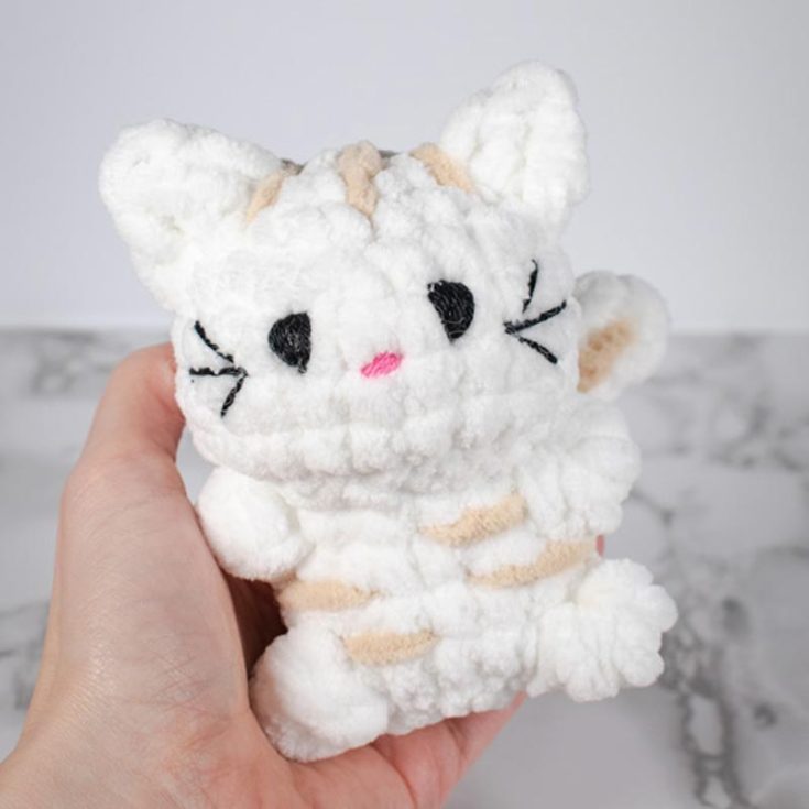 Learn how to make this easy but cute and fluffy crochet cat amigurumi pattern. The design produces a kitty sitting on its bum with its round little paws and big oversized head for an overall kawaii effect.