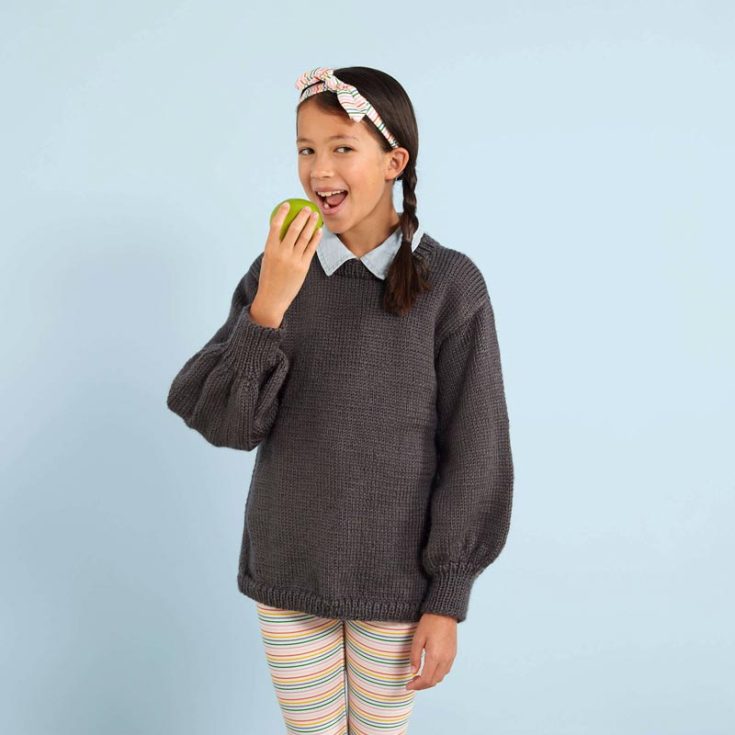 Try knitting this simple yet preppy sweater pattern for your little girl today! It&rsquo;s easy to knit and features modern bishop sleeves with a loose fit, making it a comfy piece to wear daily or on special occasions. The pattern has kids in sizes from 6 to 16.