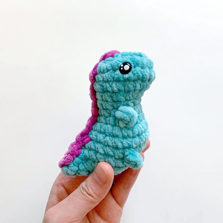 Say hello to this cute little tiny-rex pocket dino! This pattern is straightforward to crochet, and it's a no-sew amigurumi project. This project is worked from the top down using a super bulky weight velvet yarn. The finished size is 3.5" tall.