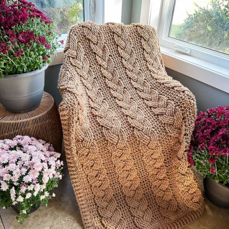 Looking for a cozy touch of luxury and warmth? This rustic chunky throw features a gorgeous cabled texture, blending cables with single crochet stitches. Perfect for intermediate-level crocheters, it measures 52&Prime; x 58&Prime;, including a 2&Prime; border
